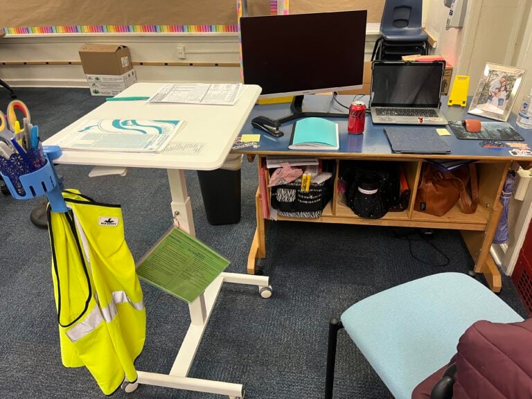 Desk set up with a rolling desk in an L shape with a regular desk. Storage showing beneath.